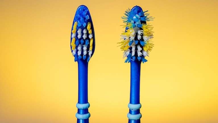 image of two toothbrushes, on one it is time to replace your toothbrush