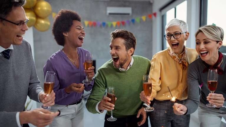Photo of friends smiling at a party accompanying an article on how a great smile helps you socially